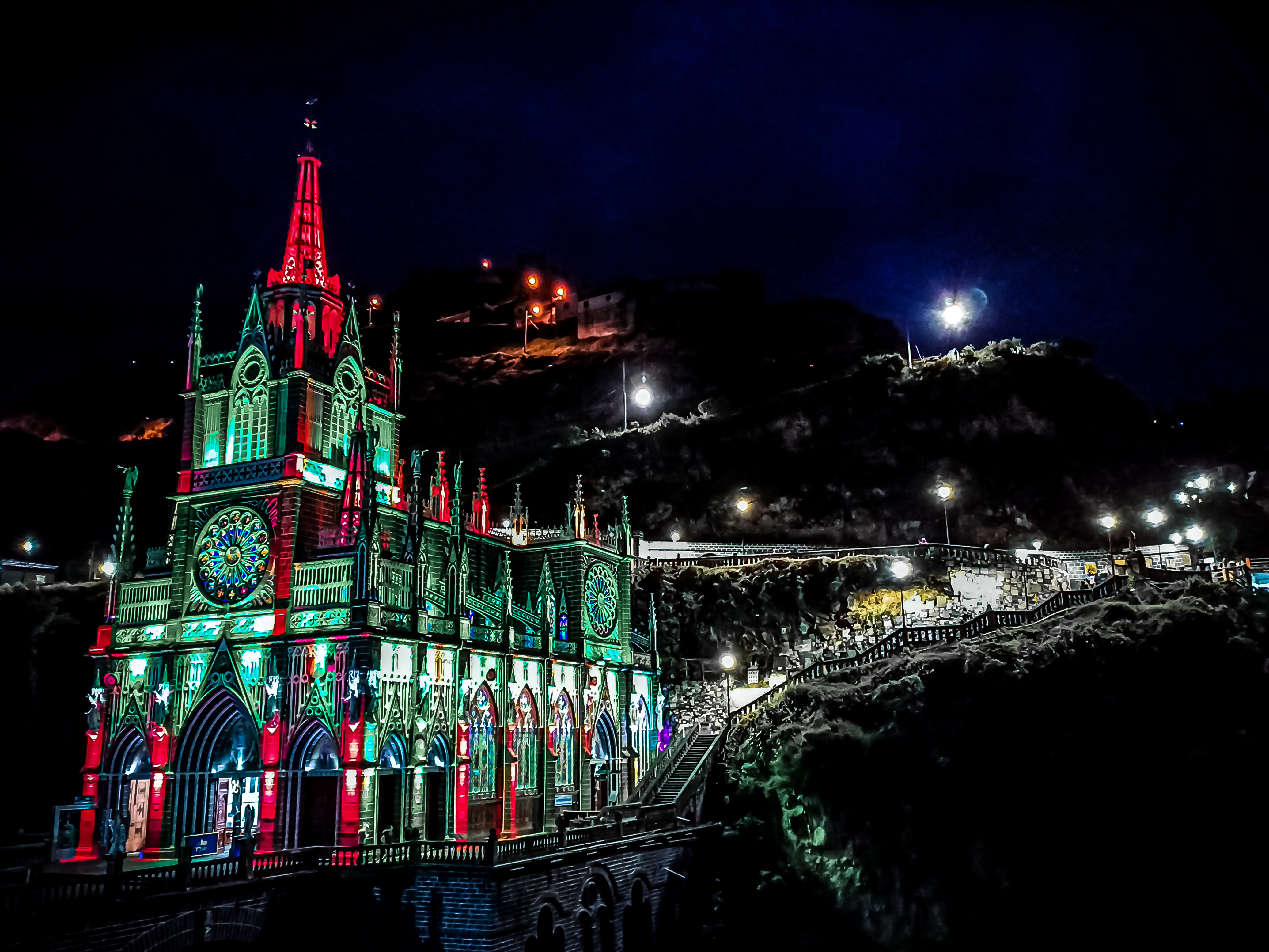 Fachada neogótica del Santuario de Nuestra Señora del Rosario de Las Lajas, iluminada de noche sobre el puente que salva el cañón del río Guáitara, cerca de Ipiales (Nariño, Colombia)