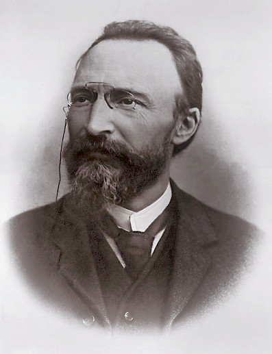 Retrato fotográfico en blanco y negro de un hombre mayor con barba blanca